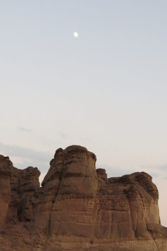 The moon rises above